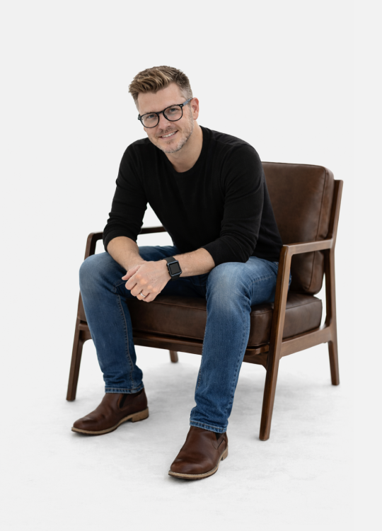 Photo of Danny sitting in a chair leaning forward.